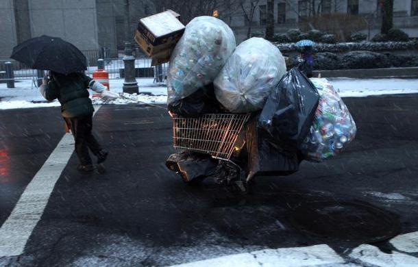 Một phụ nữ kéo xe chở đầy chai nhựa đi dưới mưa tuyết ở Manhattan, New York, Mỹ.