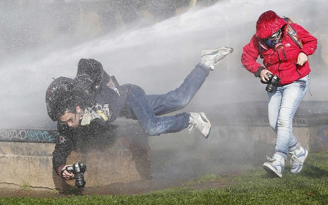 Phóng viên ảnh bị phun nước từ vòi rồng trên xe của cảnh sát chống bạo động trong cuộc biểu tình ở Chile.