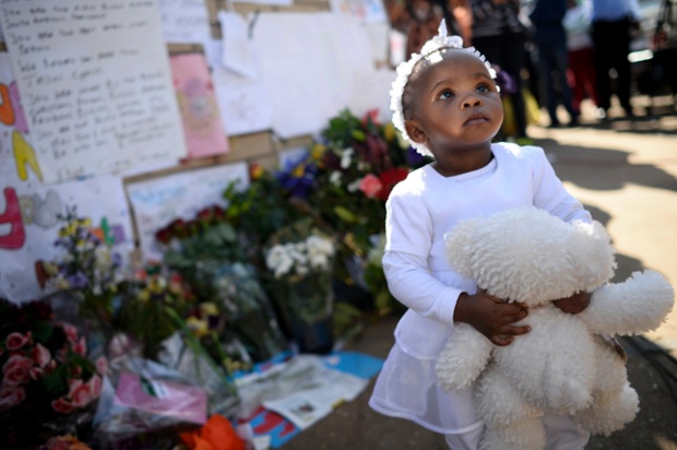 Một bé gái ôm gấu bông cùng mọi người cầu nguyện cho nhà lãnh đạo Nelson Mandela bên ngoài bệnh viện ở Pretoria, Nam Phi.
