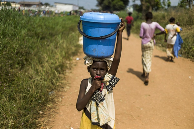 Bé gái đội sô nước trên đầu tại một tại tị nạn gần sân bay Bangui, Trung Phi.