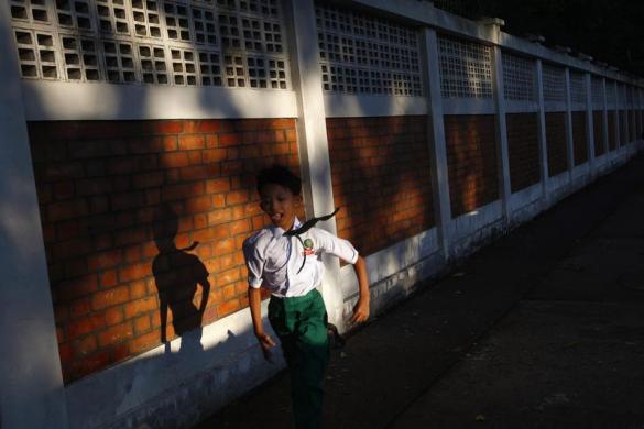 Một cậu bé hớn hở chạy khỏi trường khi tan học ở Yangon, Myanmar.