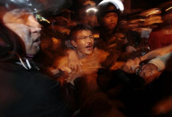 Cảnh sát chống bạo động bắt giữ một người đàn ông tham biểu tình phản đối kế hoạch tăng giá nhiên liệu của chính phủ ở tỉnh Nam Sulawesi,  Indonesia.