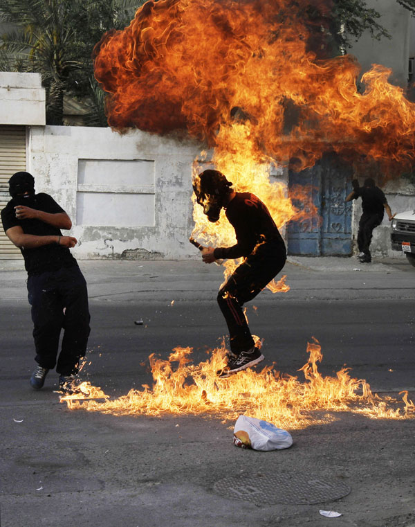 Một người biểu tình bị bắt cháy sau khi cảnh sát bắn chúng bom xăng trên tay ở Sanabis, Bahrain.