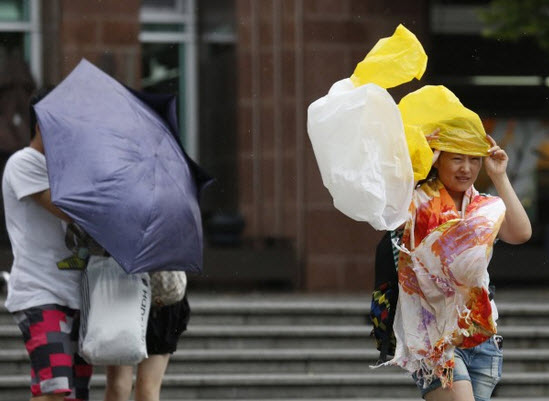 Gió lớn khiến mọi người di chuyển khó khăn ở Hong Kong.
