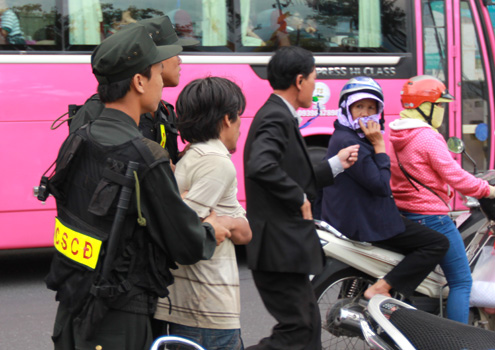 Người đàn ông trung tuổi (áo trắng) bị bắt vì sàm sỡ phụ nữ tại đường hoa xuân. Ảnh: Hoàng Huy