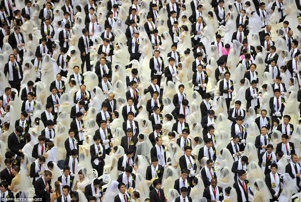 Row upon row of couples, dressed in identical white dresses and tuxedos, met at the Cheongshim Peace World Centre in Gapyeong