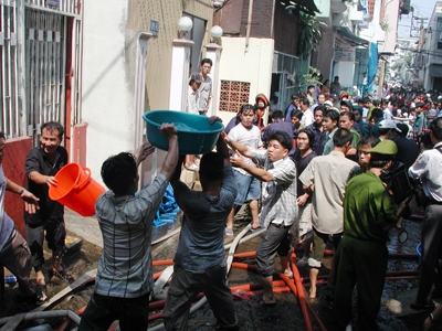 Người dân tham gia cứu hỏa khi một ngôi nhà bị cháy ở quận Tân Bình, TPHCM.
            Ảnh: L.N