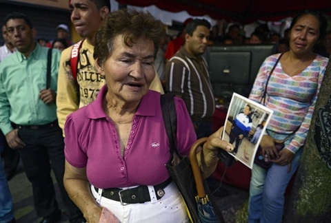 Một phụ nữ cầm trên tay tấm ảnh ông Chavez . Ảnh: