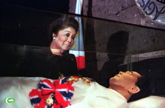 Cựu đệ nhất phu nhân Philippines Imelda Marcos đứng bên thi thể của chồng là cựu Tổng thống Philippines Ferdinand Marcos nằm trong quan tài kính tại lăng Marcos năm 1996. Ông Marcos qua đời khi sống lưu vong ở Hawaii (Mỹ) vào năm 1986. Bà Imelda Marcos đã ướp xác chồng và chuyển thi thể của ông về nước vào năm 1993.