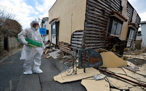 Yuzo Mihara looks at a damaged house in his neighbourhood