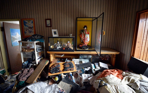 Clothes and furniture are strewn on the ground after the 11 March 2011 earthquake at the Miharas' house in the town of Namie