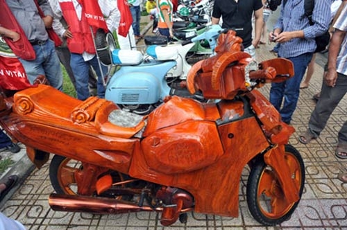  Chiếc xe máy làm bằng gỗ, phần ruột của xe không phải của dòng Vespa cổ mà nó được chế từ một chiếc xe Honda Wave. Chủ nhân của xe là anh Nguyễn Kim Bằng, một người dân thành phố Nha Trang.