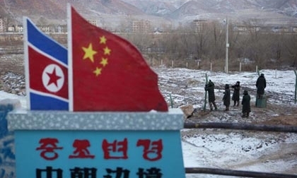 Các cảnh sát bán quân sự Trung Quốc đang xây hàng rào gần cột mốc biên giới cắm quốc kỳ Triều Tiên và Trung Quốc ở thị trấn Tumen, tỉnh Jilin, Trung Quốc. Ảnh: AP