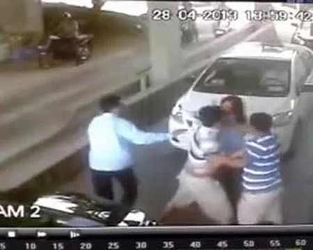 Nữ nhân viên bị nhóm người đi ô tô lôi ra khỏi phòng bán vé đánh đập. Ảnh chụp từ clip