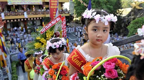 
	Các em thiếu nhi dâng những giỏ hoa lên đức Phật.