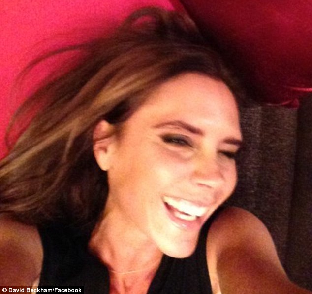 I told you she smiles: David Beckham posted a laughing snapshot of his wife Victoria on his Facebook page on Sunday 