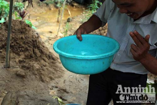 	Trưởng xóm Ngành, Nguyễn Mạnh Thỏa xem mẻ đãi vàng cám của một người cùng xã.