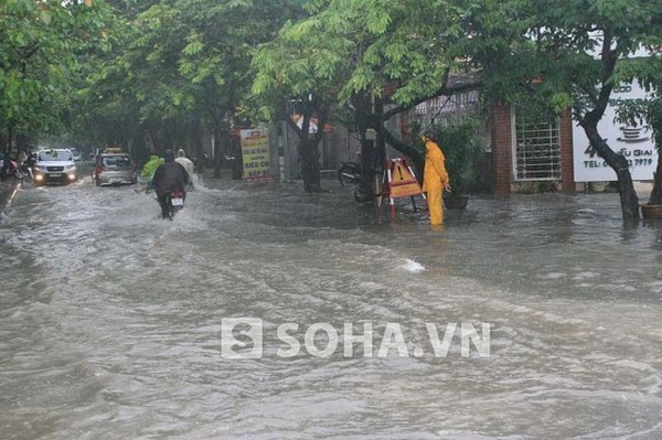 Đối diện đường Vạn Phúc (Ba Đình, Hà Nội), các xe cũng đang vất vả để vượt qua cung đường ngập lụt dưới ánh nhìn của nhân viên công ty cấp thoát nước.