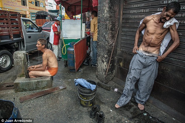 Homeless: Men bathe in the streets among street vendors and traffic