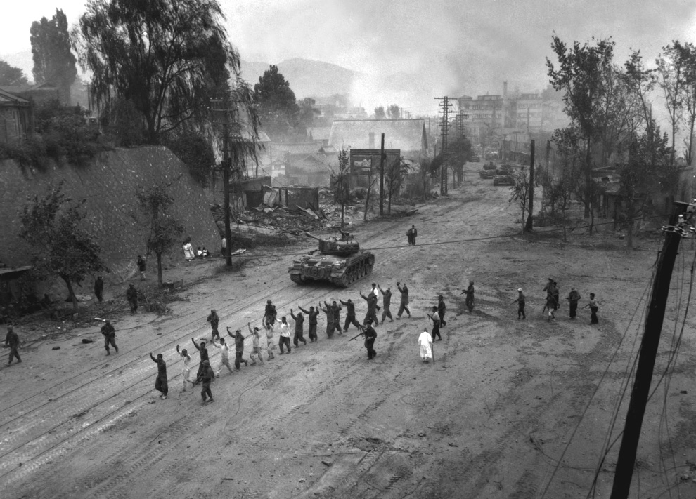  	Xe tăng Mỹ dẫn độ tù binh đi trên đường làng. Ảnh chụp 26/9/1950.