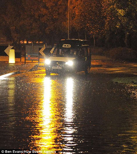 Lái xe đấu tranh thông qua một con đường ngập nước ở Cardiff, South Wales