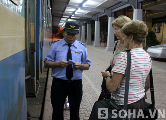 Nhân viên kiểm soát vé của Xí nghiệp Vận dụng Toa xe khách Hà Nội đang kiểm tra vé của hành khách trước khi lên tàu.
