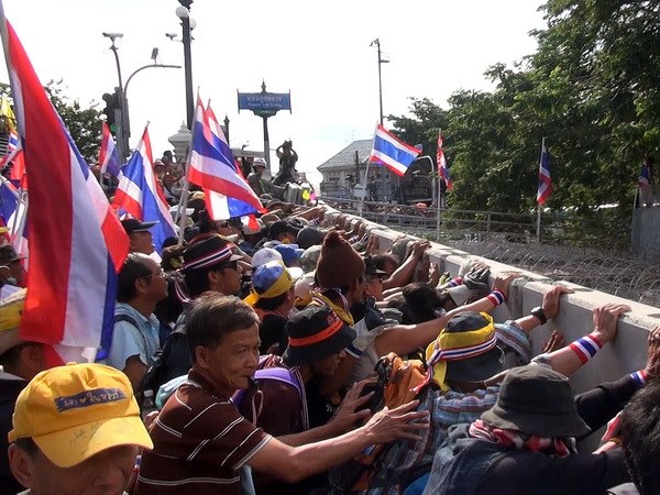  	Người biểu tình đẩy hàng rào do cảnh sát dựng trước tòa nhà chính phủ. (Ảnh: Vietnam+)