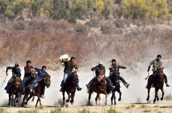  	Các kị sĩ đua nhau giành giật xác một con dê bị chặt đầu trong sự kiện Buzkashi ở quận Yuli, khu tự trị Tân Cương (Trung Quốc). Buzkashi là một môn thể thao truyền thống ở Trung Á, trong đó 2 đội kĩ sĩ sẽ đua nhau giành giật xác con dê và ném nó vào vòng tròn tính điểm.