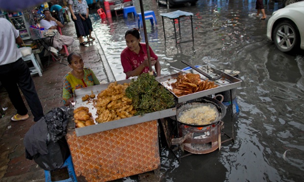 Những người bán món bánh mì trứng rán cạnh đường phố ngập nước ở Rangoon, Myanmar.