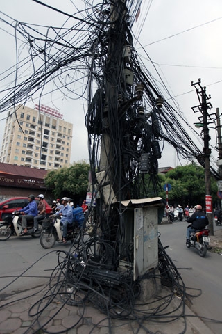 
	Đống dây loằng ngoằng dưới chân cây cột điện nằm ngã tư đường Đê La Thành - Hào Nam.