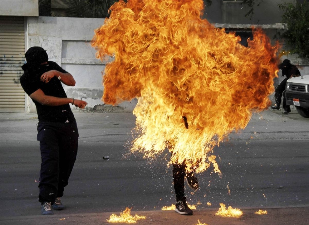  	Một người biểu tình chống chính phủ tại Bahrain chìm trong lửa sau 	khi cảnh sát chống bạo động bắn vào bom xăng trong tay người này khi người này chuẩn bị ném về phía cảnh sát