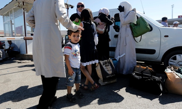 Một gia đình Syria chờ xe sau khi vượt qua biên giới sang Hatay, Thổ Nhĩ Kỳ.