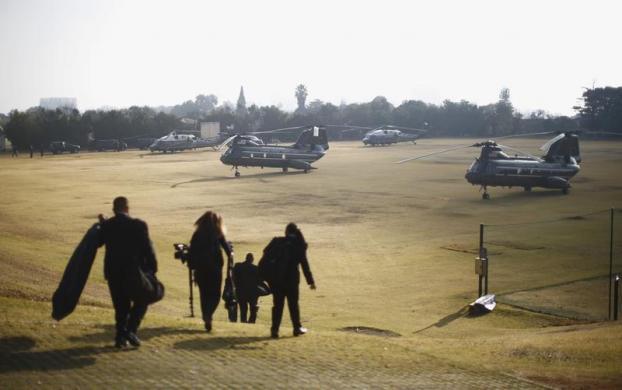 Các nhân viên của Nhà Trắng đi bộ ra các máy bay trực thăng chở Tổng thống Mỹ Barack Obama  tại một sân vận động bóng đá ở Johannesburg, Nam Phi.