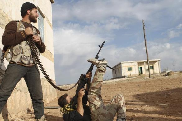 Chiến binh phiến quân nằm ngắm súng ở ngoại ô thành phố Aleppo, Syria.