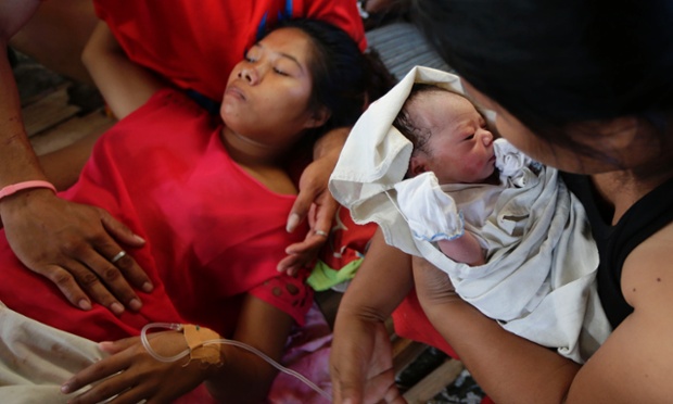 Bà mẹ trẻ Emily Ortega, 21 tuổi, hạ sinh em bé Bea Joy ngay giữa đống đổ nát tại sân bay ở thành phố Tacloban, Philippines.