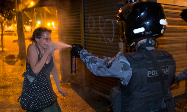 Cảnh sát xịt hơi cay vào mặt một phụ nữ tham gia biểu tình ở thành phố Rio de Janeiro, Brazil. Hàng nghìn người ở Rio de Janeiro đã tham gia biểu tình phản đối tăng giá vé các phương tiện công cộng và việc chính phủ chi hàng tỷ USD cho World Cup 2014 và Olympic 2016.