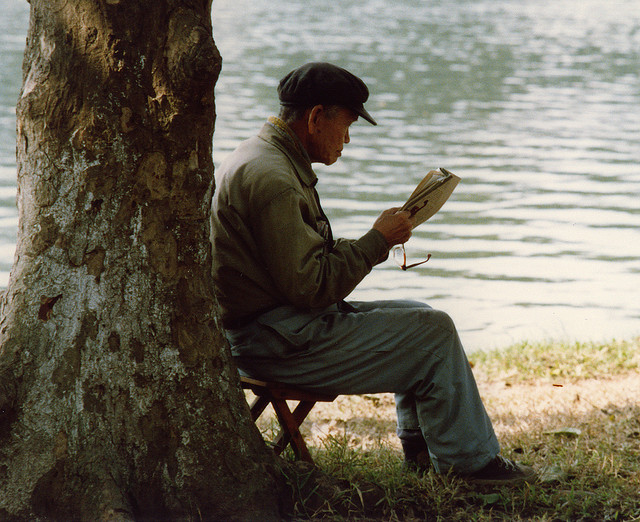 
	Một cụ ông đọc báo ven hồ.