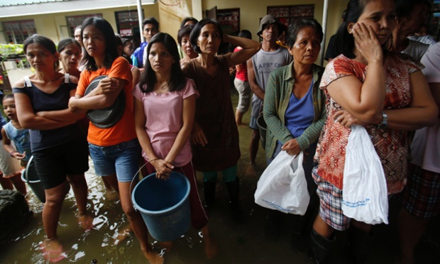 Mọi người đứng chờ nhận thực phẩm cứu trợ tại một trung tâm sơ tán lũ lụt ở Calumpit, Philippines.