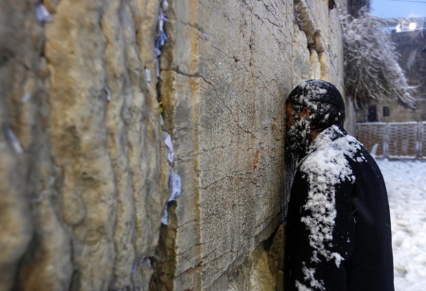 Một người đàn ông Do Thái cầu nguyện tại Tường phía tây dưới mưa tuyết ở Jerusalem.