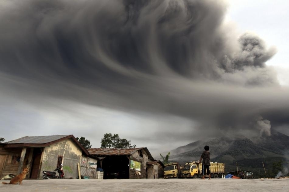  	Một đứa trẻ đang xem cảnh ngọn núi Sinabung ở phía Tây Indonesia 	phun trào. Vụ phun trào này đã khiến gần 6.000 người sống quanh chân núi phải đi sơ tán.