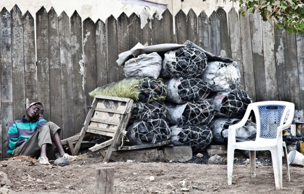 Người bán than củi ven đường tranh thủ ngủ trong khi không có khách mua tại Nairobi, Kenya.