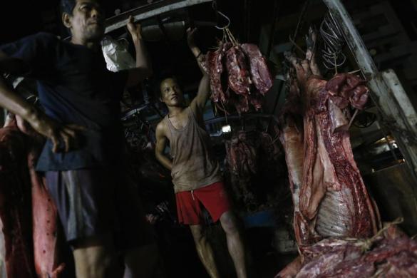 Những người đàn ông đứng trên một xe chở thịt lợn tại chợ Thanzay ở Yangon, Myanmar.