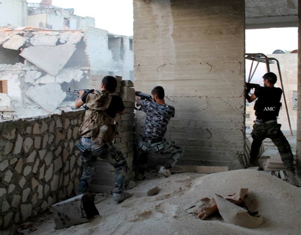 Các chiến binh của lược lượng quân đội Syria xả súng trong khi chiến đấu với quân đội chính phủ ở Aleppo, Syria.
