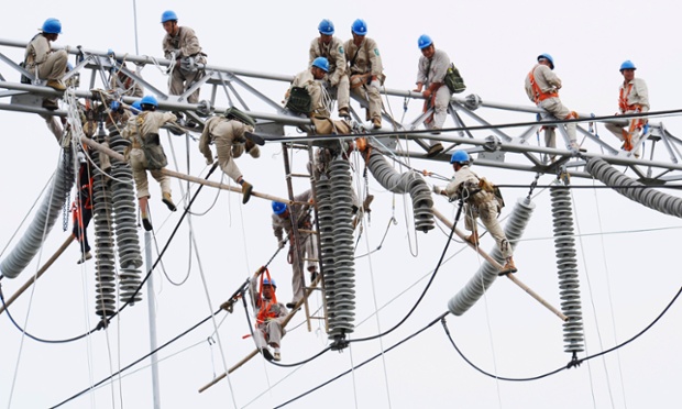 Các công nhân tham gia bảo dưỡng lưới điện cao thế ở ngoại thành phố Từ Châu thuộc tỉnh Giang Tô, Trung Quốc.