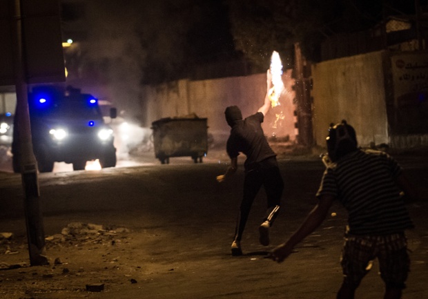 Người biểu tình ném bom xăng để ngăn chặn xe bọc thép của cảnh sát tiến vào một ngôi làng ở Abu Saiba, Bahrain.