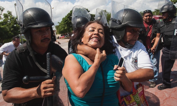 Một phụ nữ bị cảnh sát chống bạo động bắt giữ trong cuộc biểu tình của giáo viên đòi cải cách giáo dục ở Cancun, Mexico.