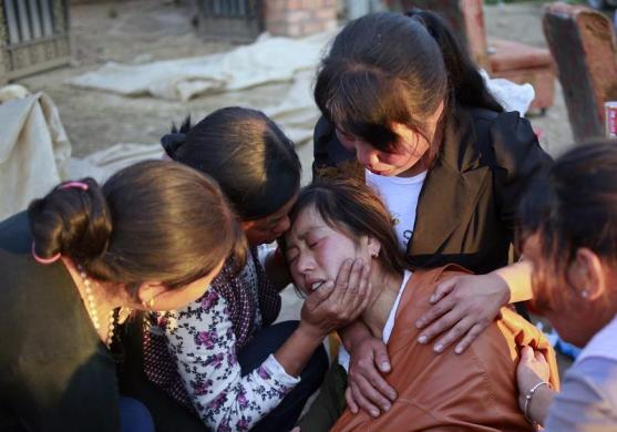 Những người thân an ủi một phụ nữ bị mất con gái trong trận động đất ở thành phố Định Tây thuộc tỉnh Cam Túc, Trung Quốc.