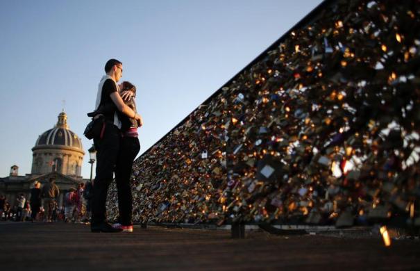 Một cặp tình nhân ôm nhau ngắm hoàng hôn cạnh dòng sông Seine ở Paris, Pháp.