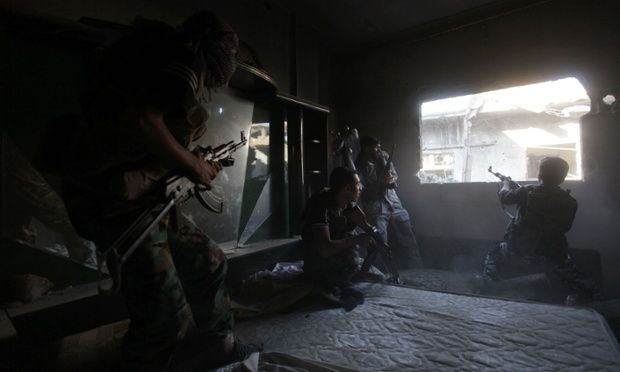 Các chiến binh phiến quân Syria đấu súng với quân đội chính phủ từ một ngôi nhà ở thành phố Aleppo, Syria.