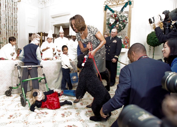 Đệ nhất phu nhân Tổng thống Mỹ bà Michelle Obama phản ứng khi chú chó Sunny làm ngã bé gái 2 tuổi Ashtyn Gardner tại Nhà Trắng, Washington.